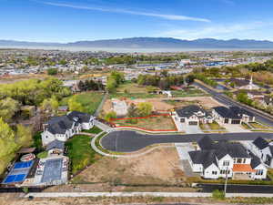 Aerial view of residential area with property boundaries highlighted and a mountainous background