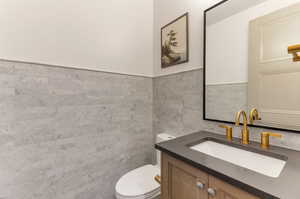 Half bath with vanity and tile walls