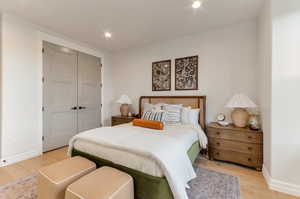 Bedroom with light wood-style flooring, a closet, and recessed lighting