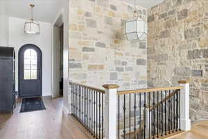 Foyer entrance with light wood-style floors and arched walkways