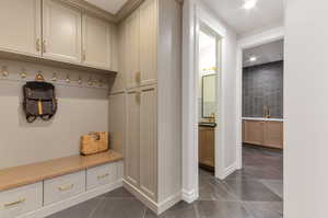 Mudroom featuring baseboards and dark tile patterned flooring