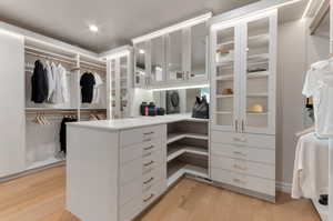 Walk in closet with light wood-style flooring