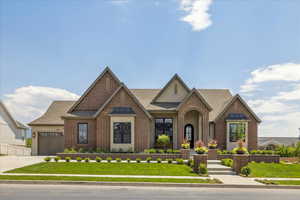 English style home with brick siding, roof with shingles, and stucco siding