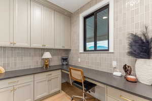 Office featuring built in desk and light wood-style floors