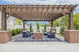 Fenced backyard with a patio, a mountain view, a pergola, and an outdoor living space with a fire pit