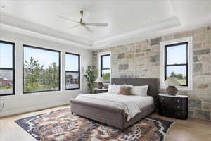 Bedroom featuring multiple windows, light wood-style floors, and a ceiling fan