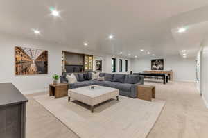 Living area featuring light colored carpet and recessed lighting