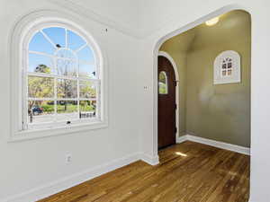 Foyer entrance featuring dark wood-style floors and arched walkways