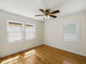 Unfurnished room with light wood-style floors, crown molding, and a ceiling fan