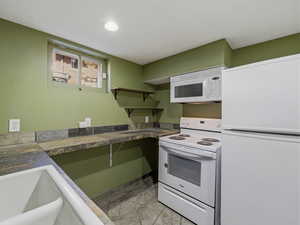 Kitchen with white appliances and a sink