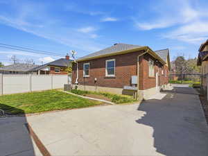 View of side of property featuring brick siding, a shingled roof, and concrete driveway