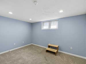 Basement featuring carpet floors, a textured ceiling, and recessed lighting