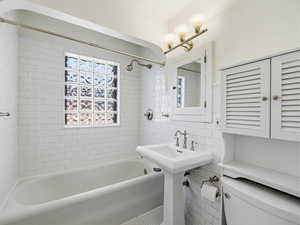 Bathroom with bathing tub / shower combination and tile walls