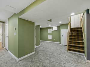 Below grade area featuring stairway and recessed lighting