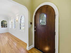 Foyer with arched walkways and light wood finished floors