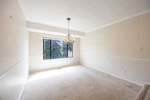 Formal dining area with chandelier, chair rail and crown moulding.