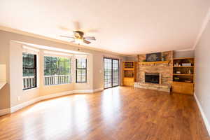 Brick surround fireplace in family room with hardwood flooring, deck access and views through the bay window.
