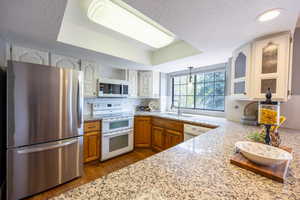 Kitchen with granite countertops, appliances and view of the backyard.