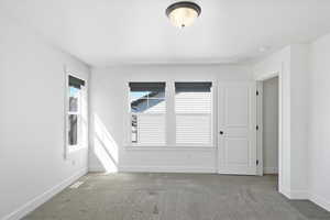 Carpeted empty room featuring baseboards