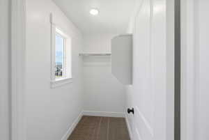 Walk in closet featuring dark carpet