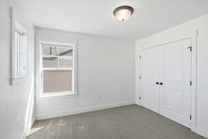 Unfurnished bedroom with dark colored carpet and a closet