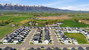 Aerial view of property and surrounding area with nearby suburban area and a mountain backdrop