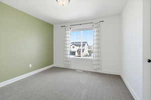 Spare room with light colored carpet and baseboards