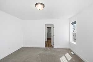 Unfurnished bedroom featuring baseboards and carpet