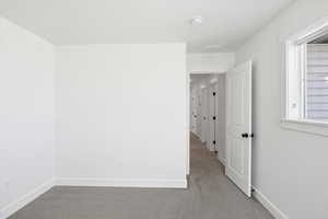 Empty room featuring light colored carpet and baseboards
