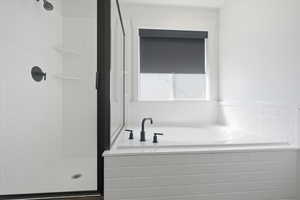 Full bath featuring a bath and a shower stall