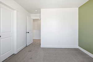 Carpeted spare room with baseboards