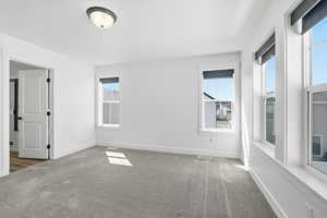 Empty room featuring carpet and baseboards