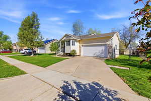 View of front of home with an attached garage, a gate, and driveway