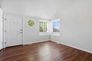 Entryway featuring lofted ceiling and dark wood-style flooring