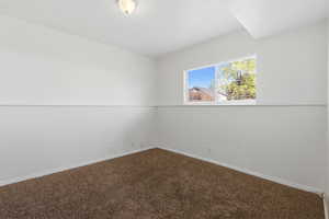 Unfurnished room with dark carpet and baseboards