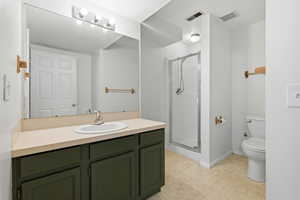 Full bath with a stall shower, vanity, and light floors