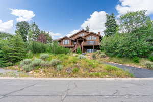 View of front of house with a chimney and a deck