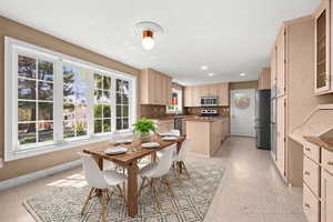 Dining room with light tile patterned floors and recessed lighting