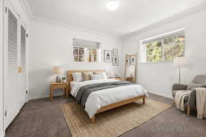 Bedroom with crown molding, carpet flooring, multiple windows, and a closet