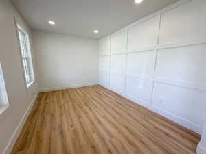 Empty room featuring light wood-type flooring and recessed lighting