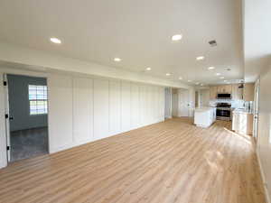 Unfurnished living room with light wood-type flooring and recessed lighting