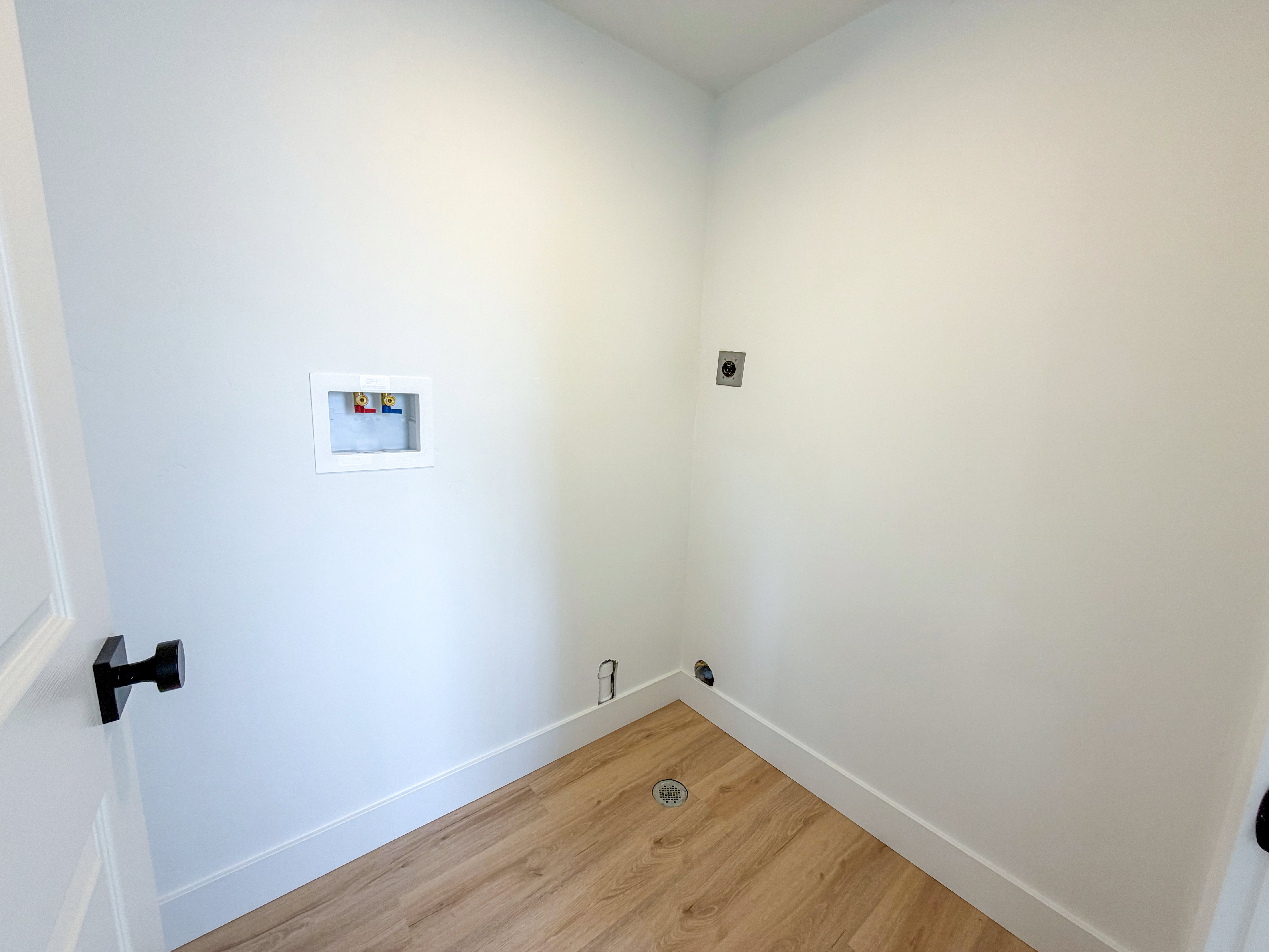 Laundry area featuring light wood-style flooring, washer hookup, and electric dryer hookup