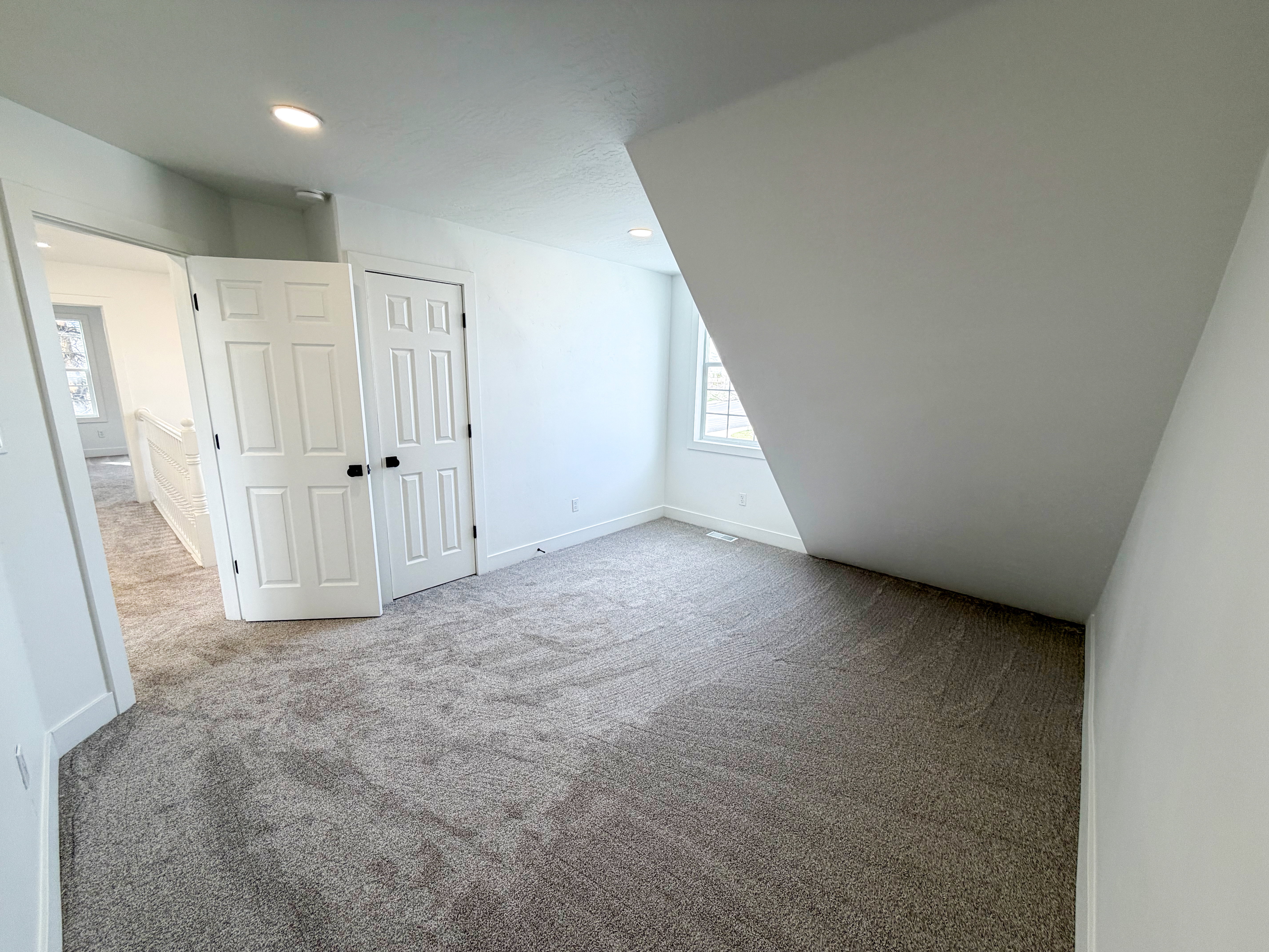 Bonus room featuring light colored carpet and baseboards