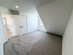Bonus room featuring light colored carpet and baseboards