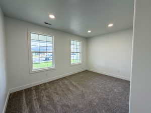 Spare room with dark carpet and recessed lighting