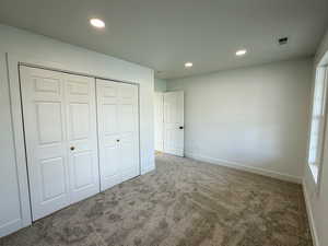 Unfurnished bedroom featuring carpet, a closet, and recessed lighting