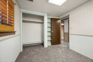Unfurnished bedroom featuring dark carpet, crown molding, and wallpapered walls
