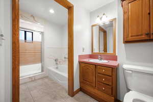 Full bath with a bath, a stall shower, vanity, and light tile patterned floors
