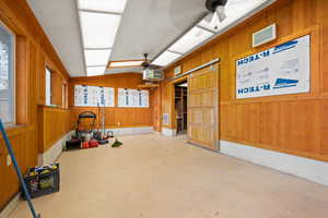 Workout area with wooden walls, lofted ceiling, a heating unit, and a ceiling fan