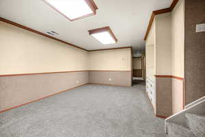 Unfurnished room featuring light colored carpet and ornamental molding